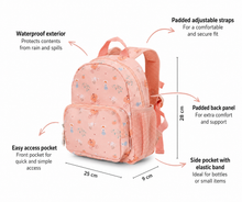 Load image into Gallery viewer, A pink patterned backpack shown with callout lines and text labels explaining its features, including padded adjustable straps, waterproof exterior, easy access pocket, side pocket with elastic band, and dimensions of 25 cm by 9 cm by 28 cm.