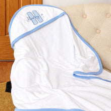 Load image into Gallery viewer, White baby towel with blue trim draped over a beige chair.