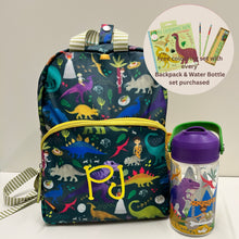 Load image into Gallery viewer, A children's backpack with a dinosaur print and a yellow monogram 'PJ' on the front, shown next to a matching water bottle. The backpack has a yellow zipper, a striped top handle, and a matching shoulder strap.