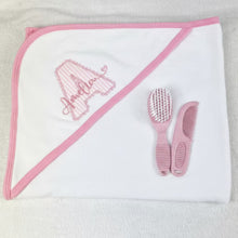 Load image into Gallery viewer, White hooded towel with pink trim and baby grooming tools on a light gray background