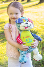 Load image into Gallery viewer, Child holding her new personalised Cubbie patchwork dog teddy. the dogs light green tummy has been embroidered with "I belong to Ella"